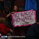 Illustration for article titled Code Pink Co-Founder Covered With American Flag at RNC While Holding Anti-Racist Sign